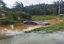 Perodua Bezza terperangkap banjir, mangsa sempat berpaut pada tiang papan tanda